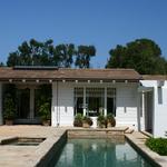 Pool with dining beyond, looking through space on axis to koi pond's bowed bay window.