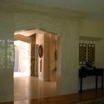 Living room portal of cut limestone, looking down short gallery towards entry.