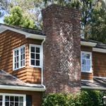 Colonial home:  Detail of chimney brick work with eave and gable venting in background.