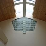 Glass block interior window below skylight shares light into Master Gallery.