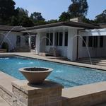 From the courtyard look toward water fall element in background and family room outdoor sitting area in the foreground.  